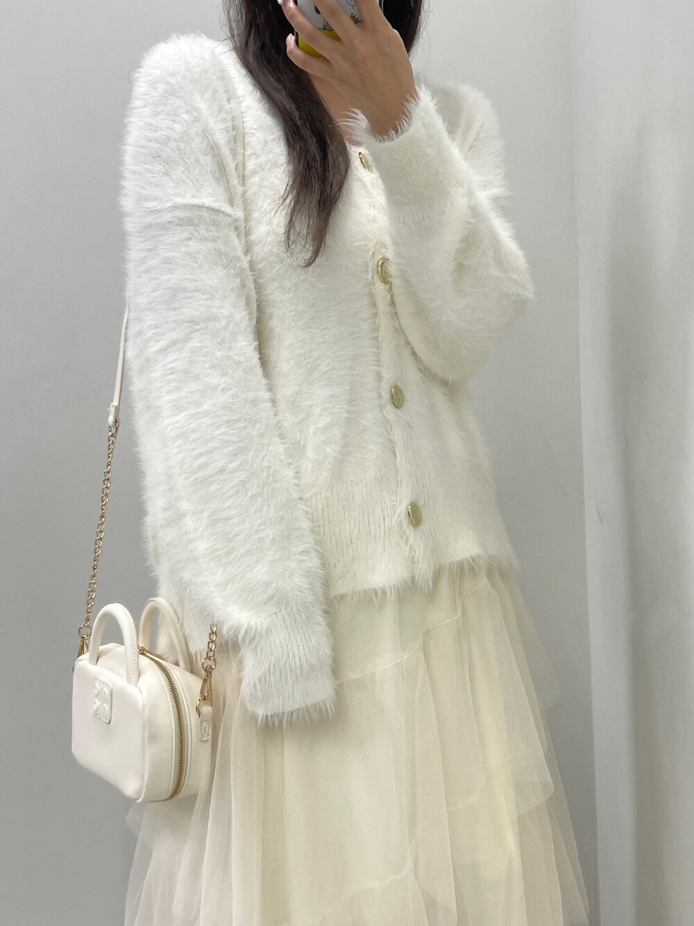 ホワイト系のカーディガン/ボレロ、ホワイト系のスカート、ホワイト系のボストンバッグを着用したレディースの秋コーディネートの5枚目の写真