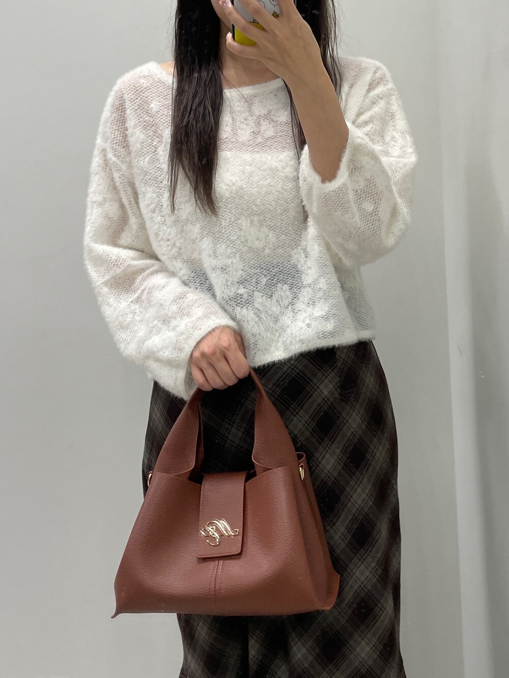 ホワイト系のニット/セーター、ブラウン系のスカート、ブラウン系のハンドバッグを着用したレディースの秋コーディネートの7枚目の写真