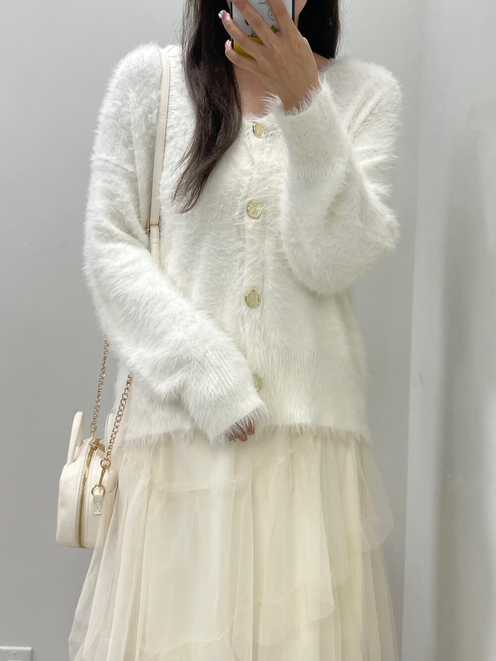 ホワイト系のカーディガン/ボレロ、ホワイト系のスカート、ホワイト系のボストンバッグを着用したレディースの秋コーディネートの4枚目の写真