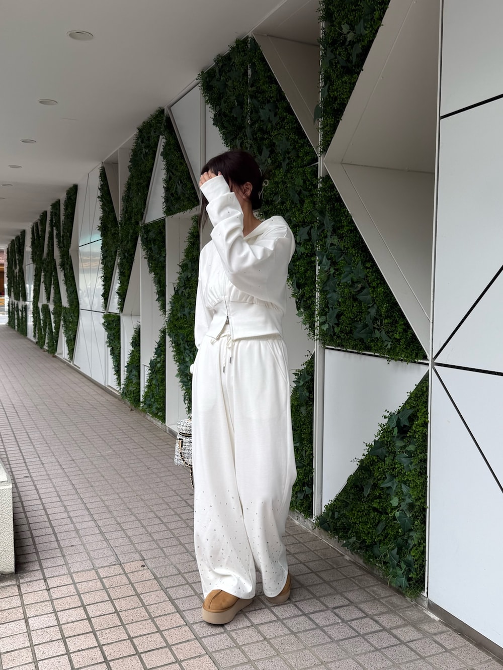 ホワイト系のパーカー、ホワイト系のスウェットパンツ、イエロー系のサンダルを着用したレディースの秋コーディネートの3枚目の写真