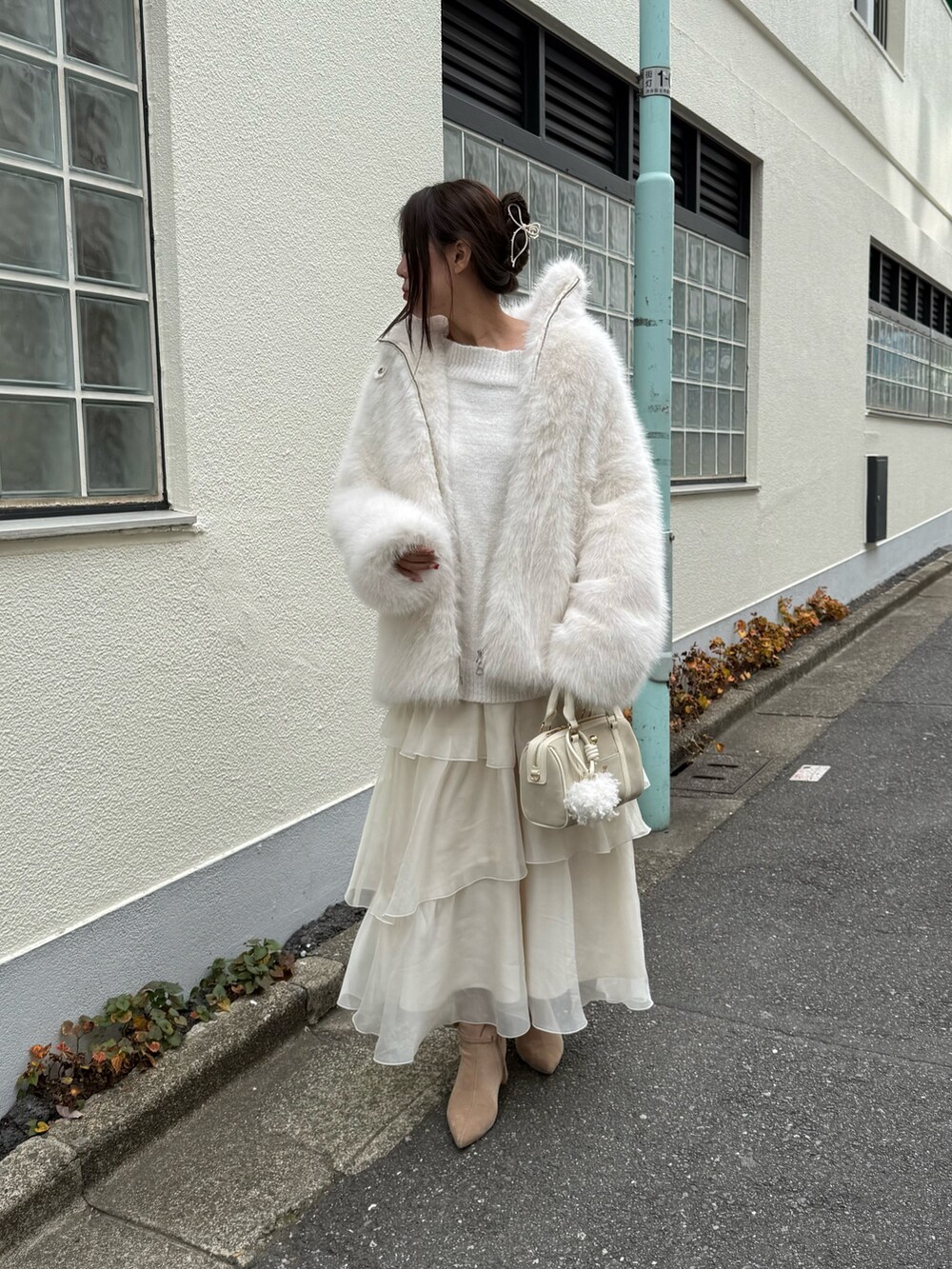 ホワイト系のその他アウター、ホワイト系のボストンバッグ、ベージュ系のブーツを着用したレディースの秋コーディネートの4枚目の写真