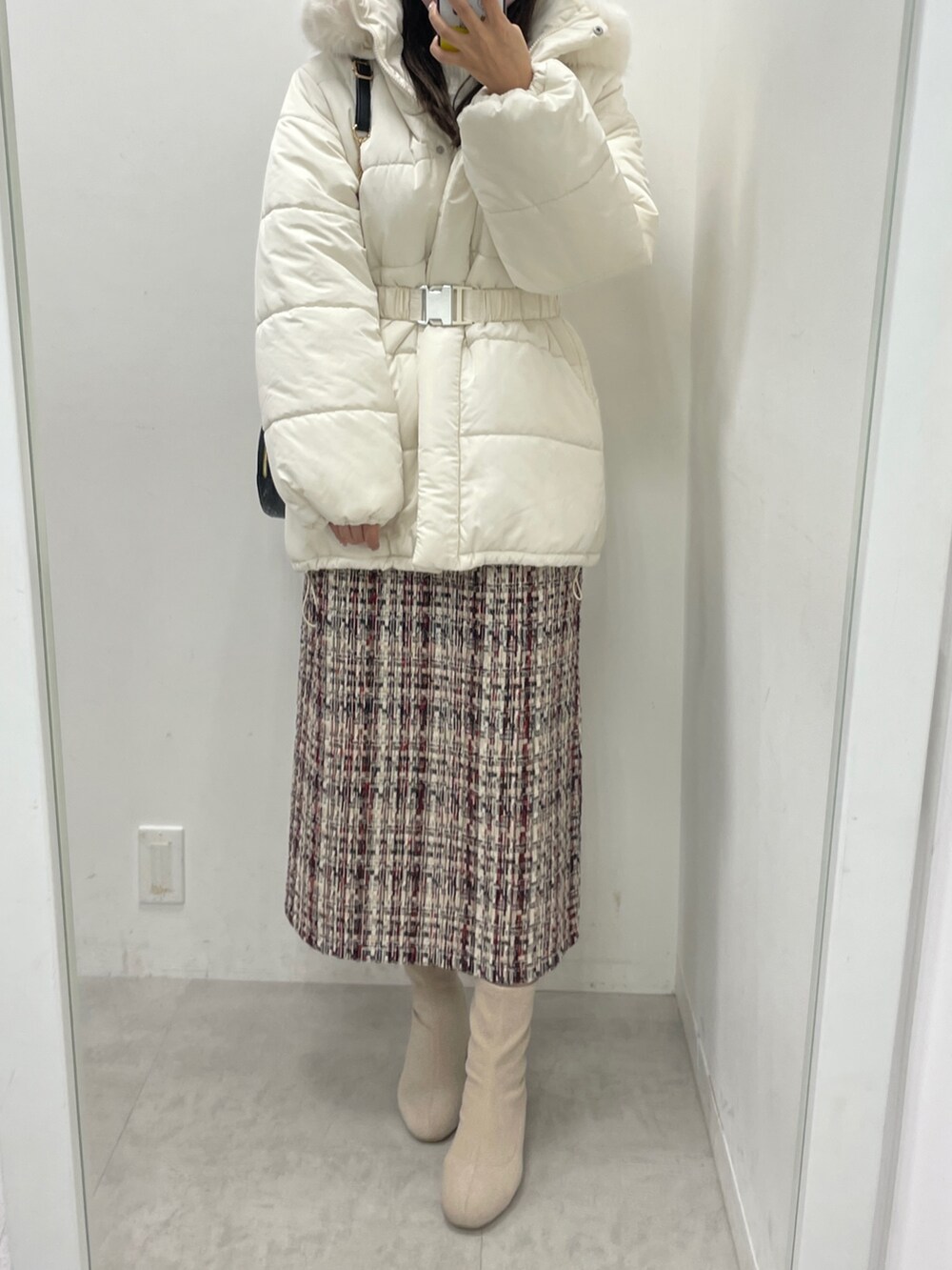 レッド系のジャンパースカート、ホワイト系のニット/セーター、ブラック系のショルダーバッグを着用したレディースの秋コーディネートの4枚目の写真