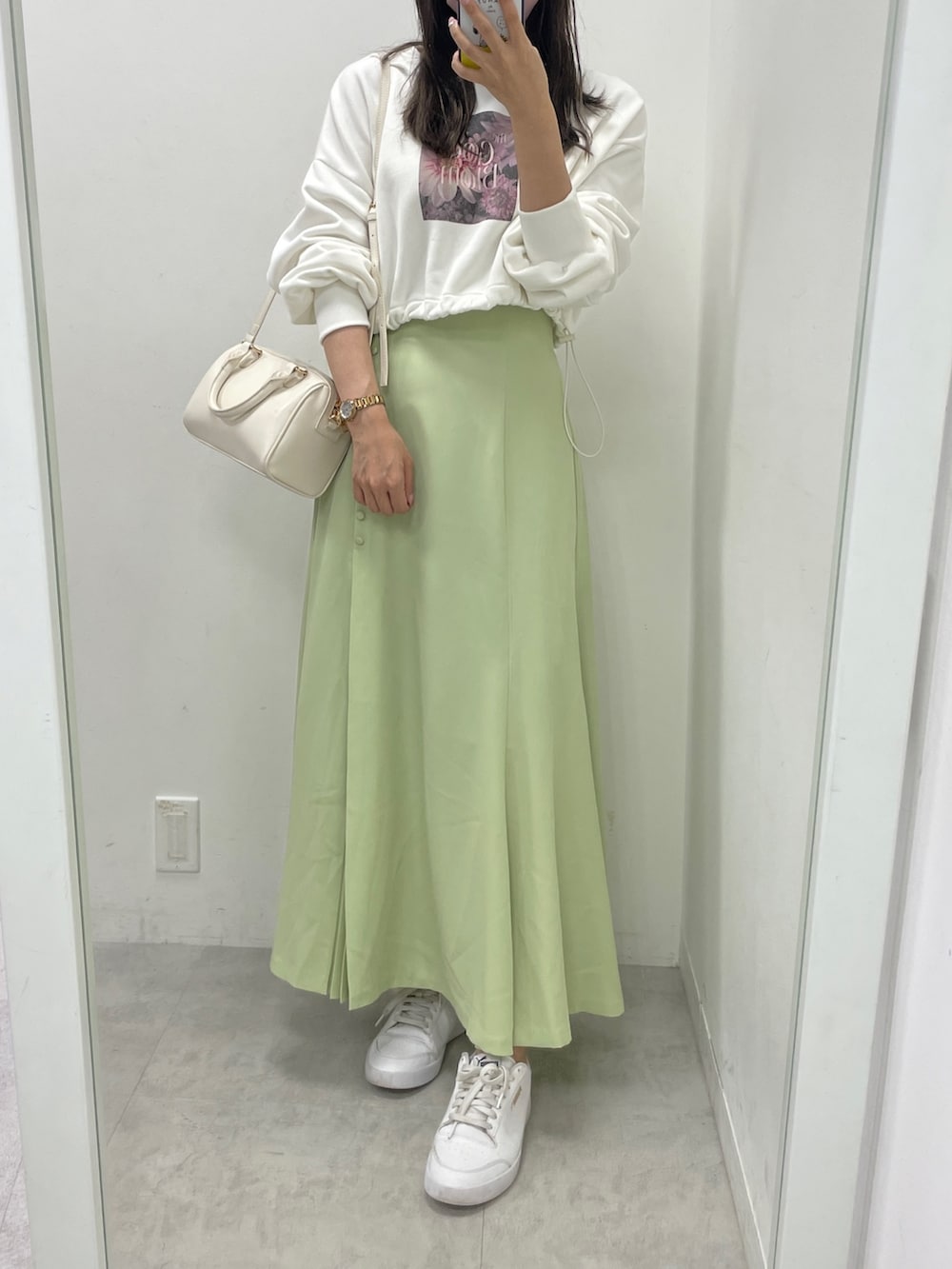 ホワイト系のダウンジャケット/コート、ホワイト系のスウェット、グリーン系のスカートを着用したレディースの秋コーディネートの5枚目の写真