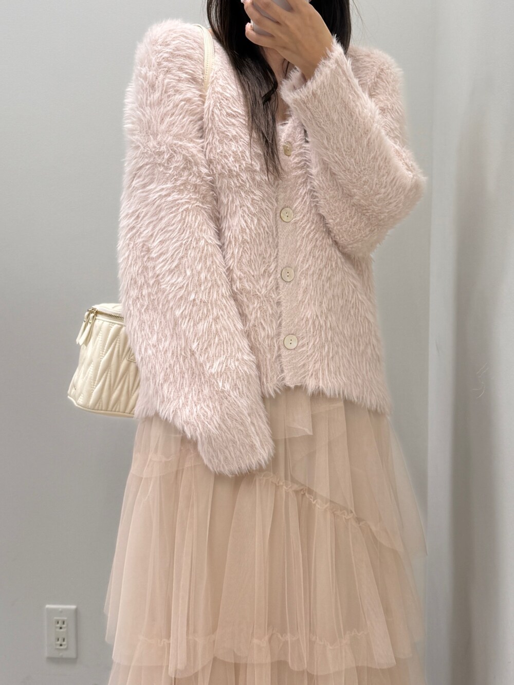 ピンク系のカーディガン/ボレロ、ホワイト系のショルダーバッグ、ブラウン系のブーツを着用したレディースの秋コーディネートの3枚目の写真