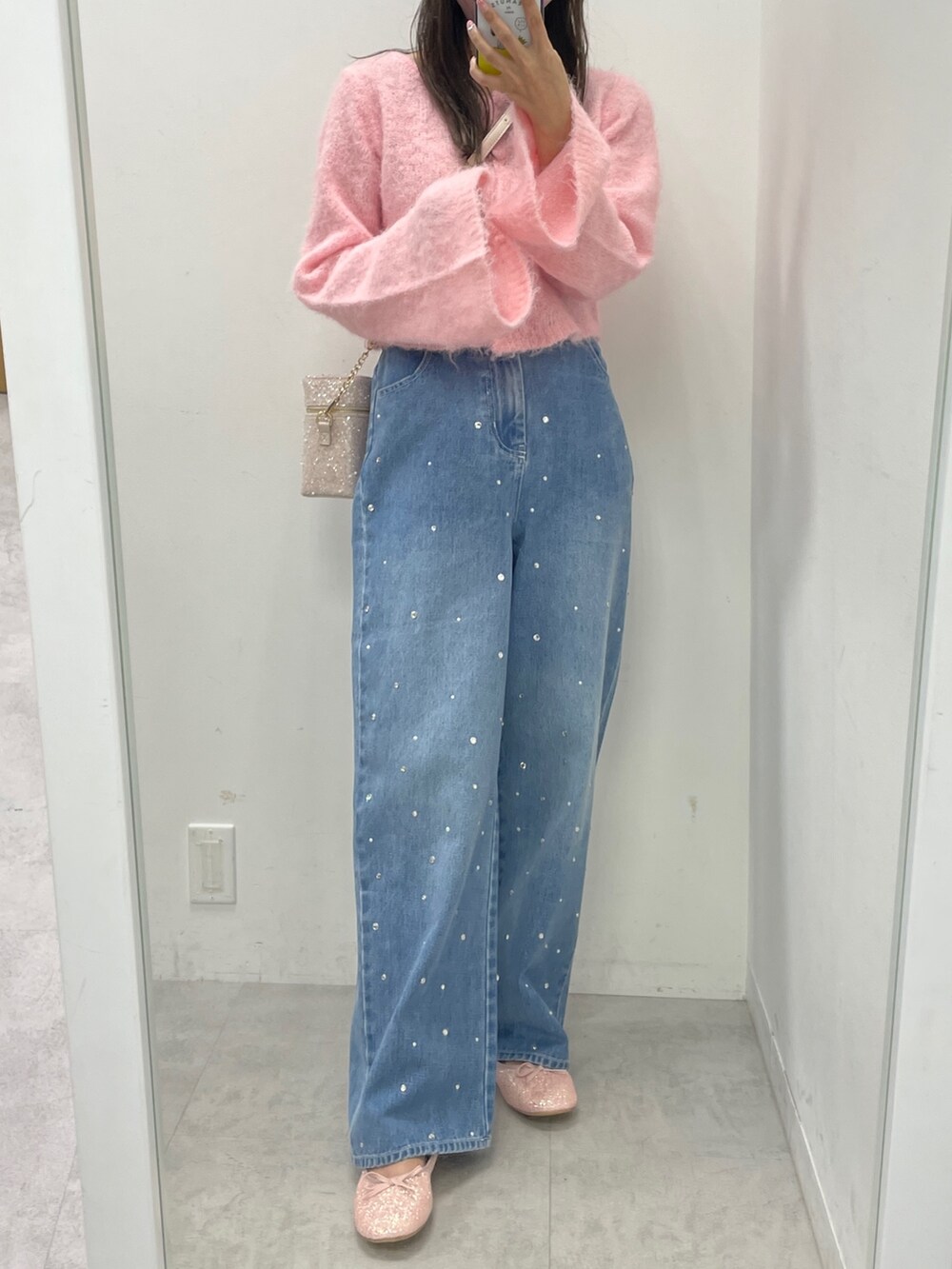 ピンク系のニット/セーター、ブルー系のデニムパンツ、ピンク系のバレエシューズを着用したレディースの秋コーディネートの3枚目の写真