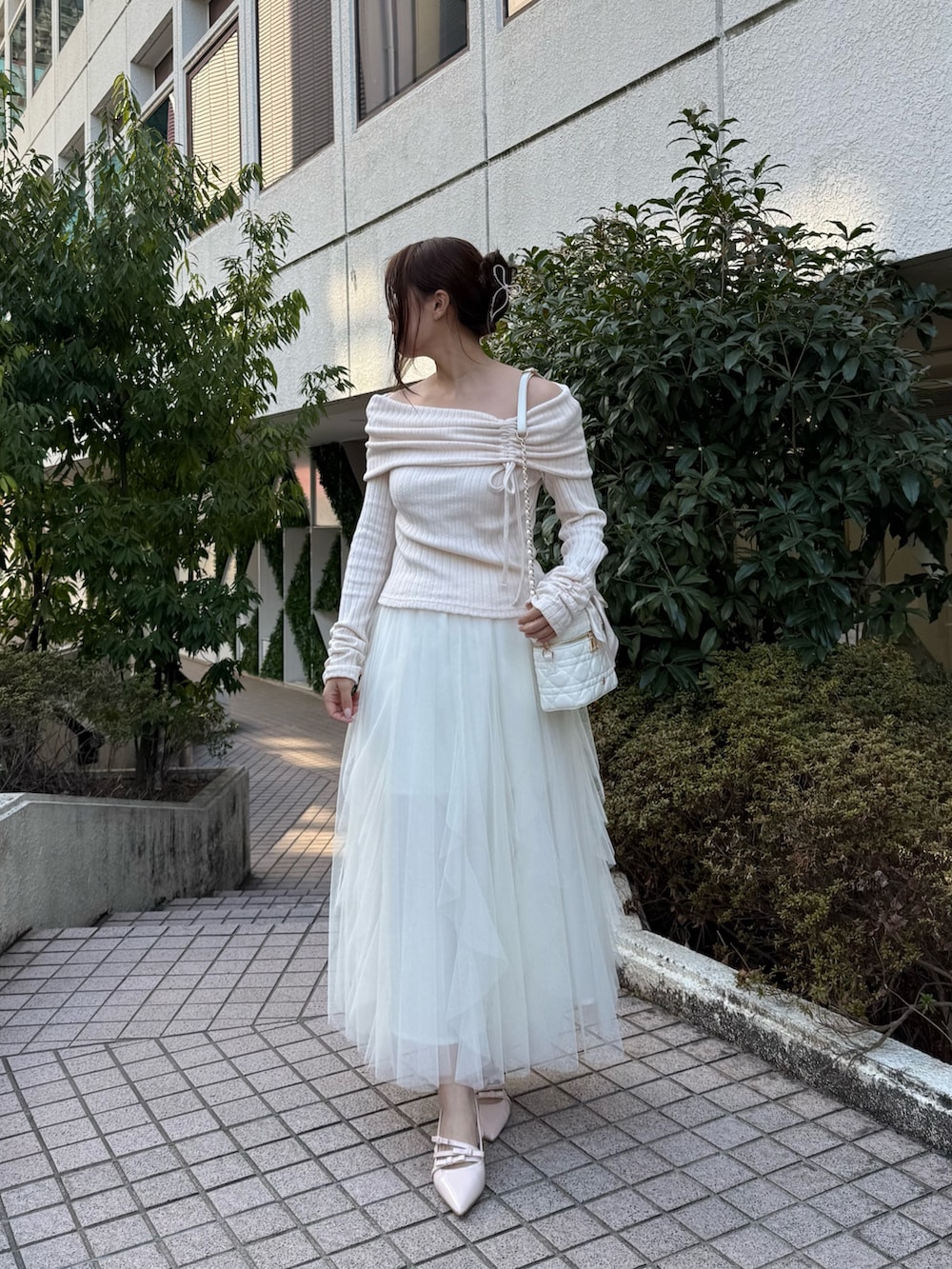 ピンク系のTシャツ/カットソー、ホワイト系のスカート、ホワイト系のショルダーバッグを着用したレディースの冬コーディネートの3枚目の写真