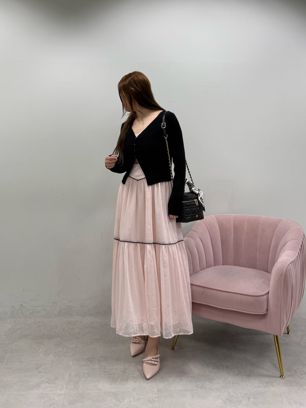 ピンク系のワンピース、ブラック系のショルダーバッグ、ピンク系のパンプスを着用したレディースの春コーディネートの2枚目の写真