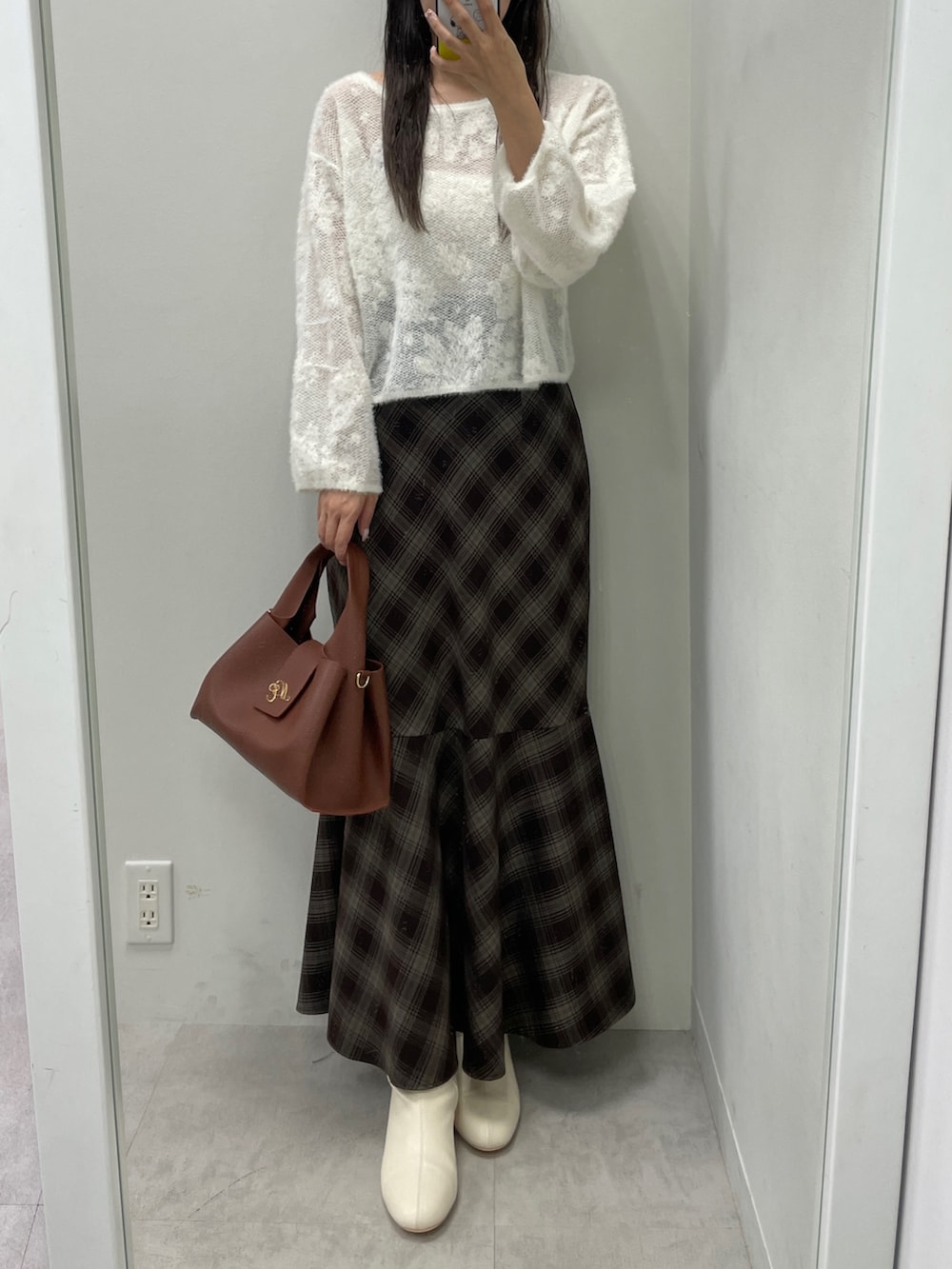 ホワイト系のニット/セーター、ブラウン系のスカート、ブラウン系のハンドバッグを着用したレディースの秋コーディネートの4枚目の写真