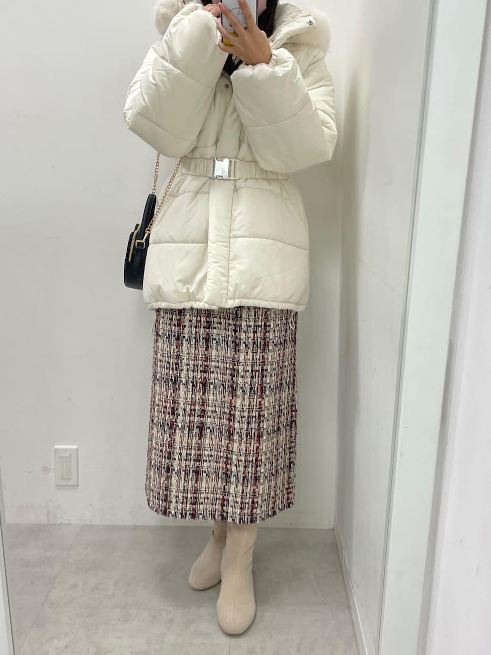 レッド系のジャンパースカート、ホワイト系のニット/セーター、ブラック系のショルダーバッグを着用したレディースの秋コーディネートの6枚目の写真