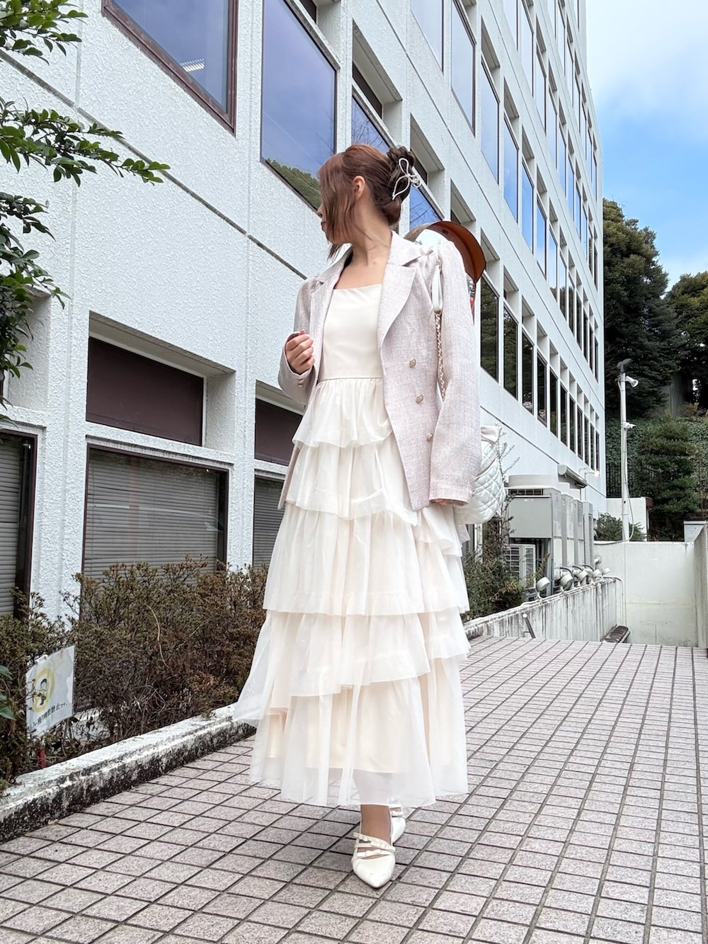 ピンク系のテーラードジャケット、ホワイト系のワンピース、ホワイト系のショルダーバッグを着用したレディースの冬コーディネートの4枚目の写真