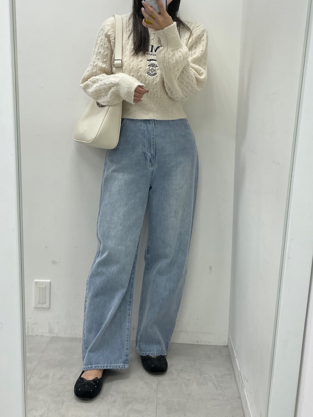 ホワイト系のニット/セーター、ブルー系のデニムパンツ、ブラック系のバレエシューズを着用したレディースの秋コーディネートの2枚目の写真