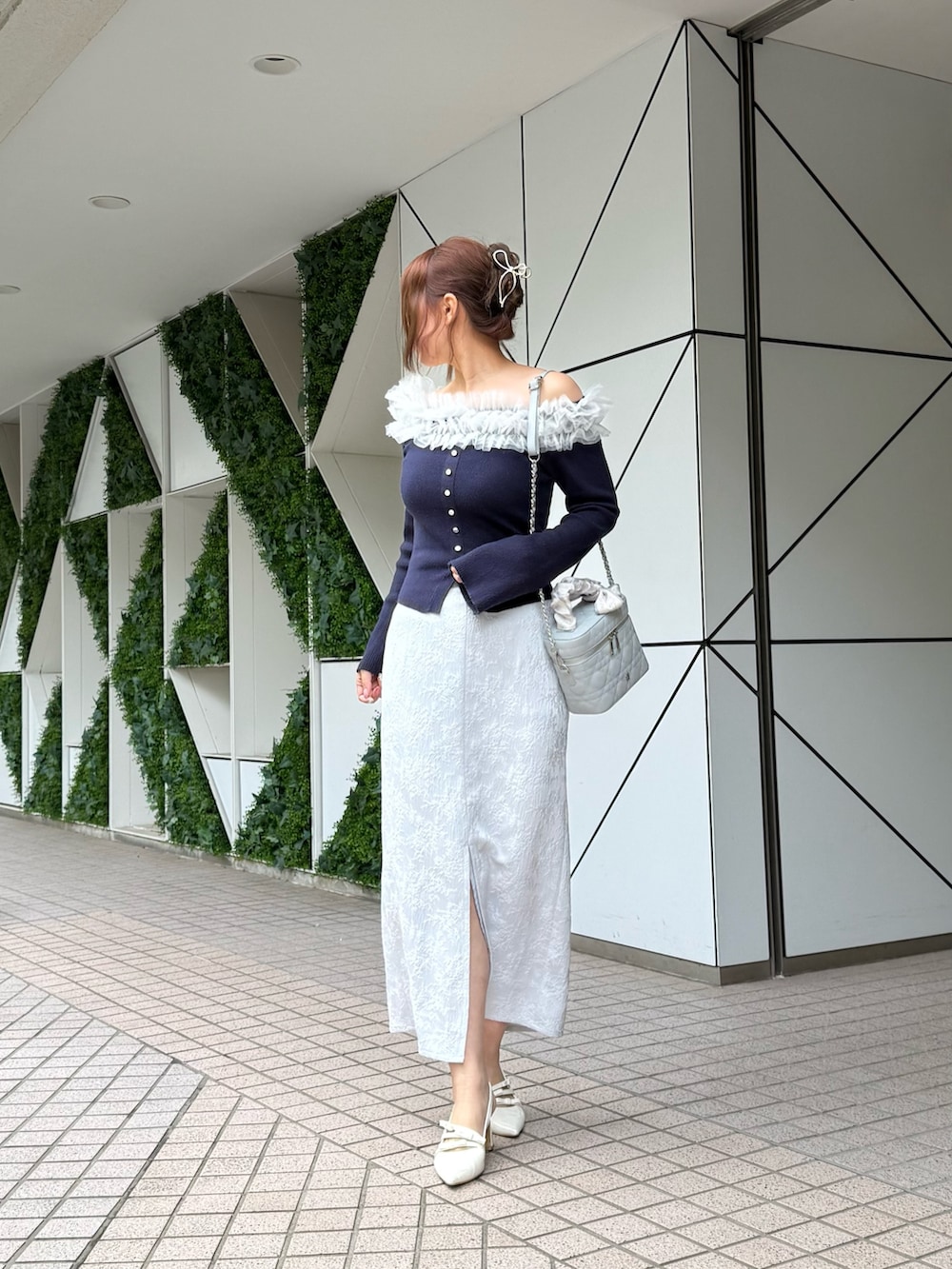 ブルー系のニット/セーター、ブルー系のショルダーバッグ、ブルー系のスカートを着用したレディースの冬コーディネートの2枚目の写真