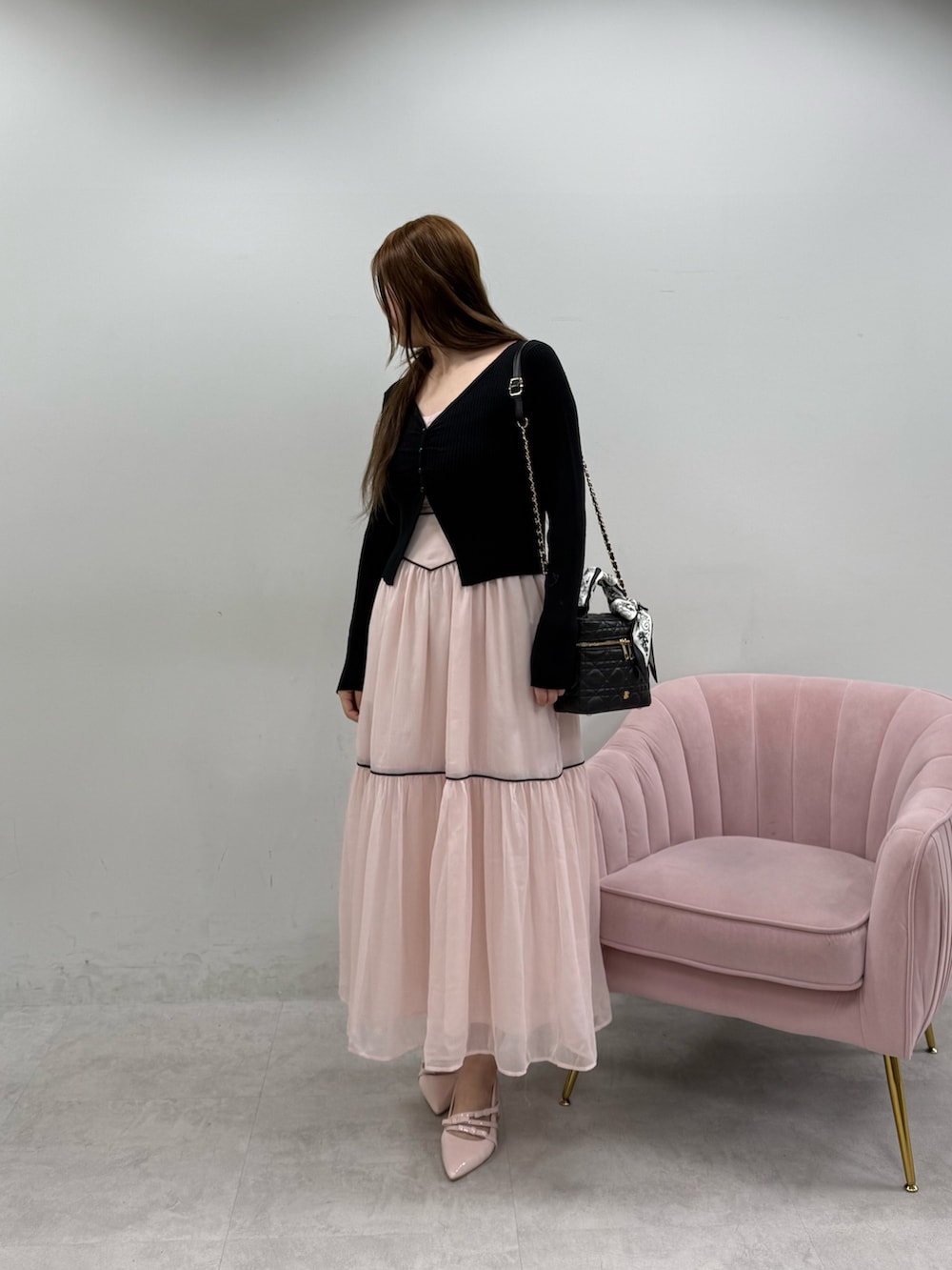 ピンク系のワンピース、ブラック系のショルダーバッグ、ピンク系のパンプスを着用したレディースの春コーディネートの3枚目の写真
