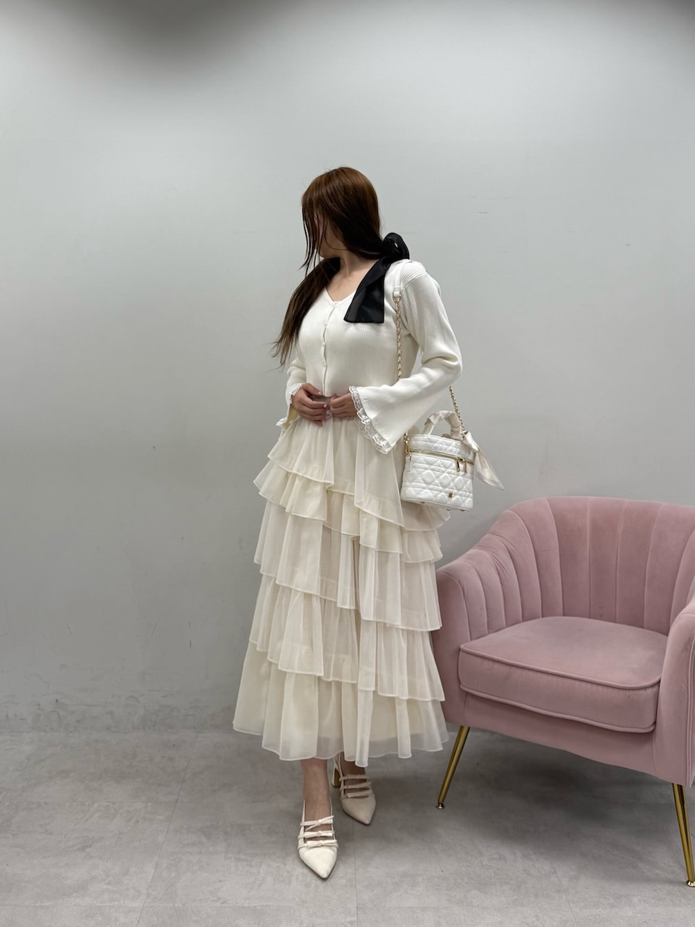 ホワイト系のカーディガン/ボレロ、ホワイト系のワンピース、ホワイト系のショルダーバッグを着用したレディースの春コーディネートの2枚目の写真