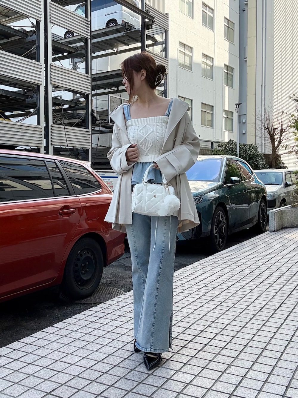 ホワイト系のトレンチコート、ホワイト系のその他トップス、ブルー系のデニムパンツを着用したレディースの冬コーディネートの2枚目の写真