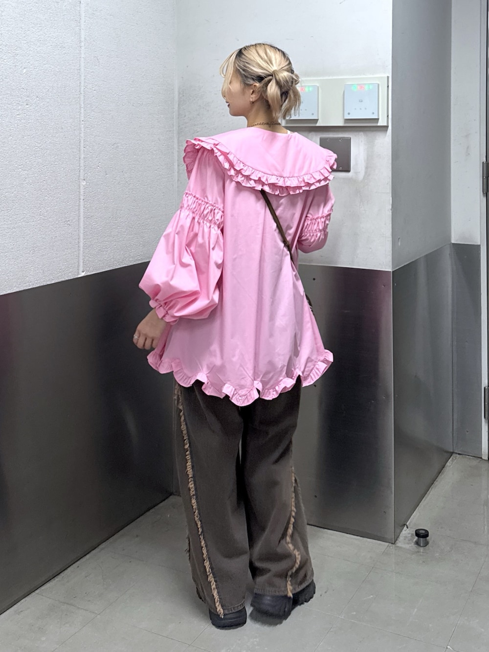 ホワイト系のワンピース、ブラウン系のデニムパンツを着用したレディースの春コーディネートの3枚目の写真