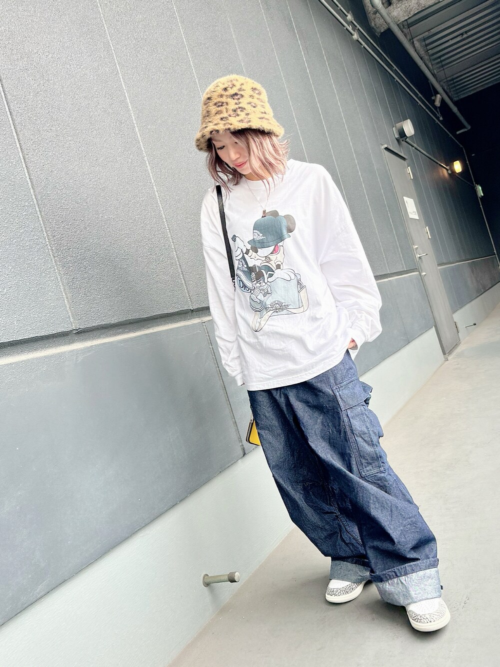 ブルー系のデニムパンツ、ブラウン系のハットを着用したレディースの秋コーディネートの2枚目の写真