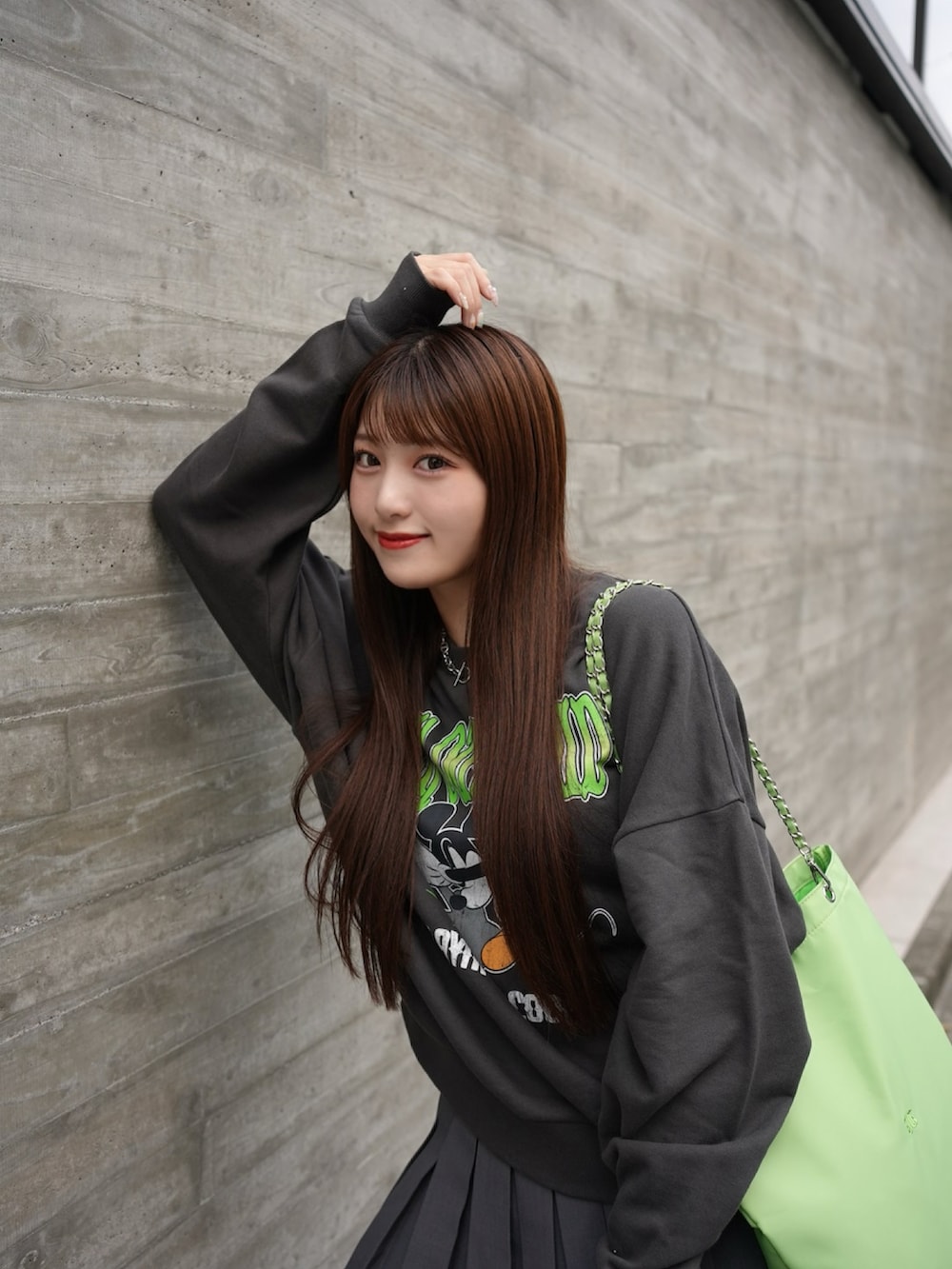 ブラック系のスウェット、グリーン系のトートバッグ、グレー系のスカートを着用したレディースの秋コーディネートの3枚目の写真