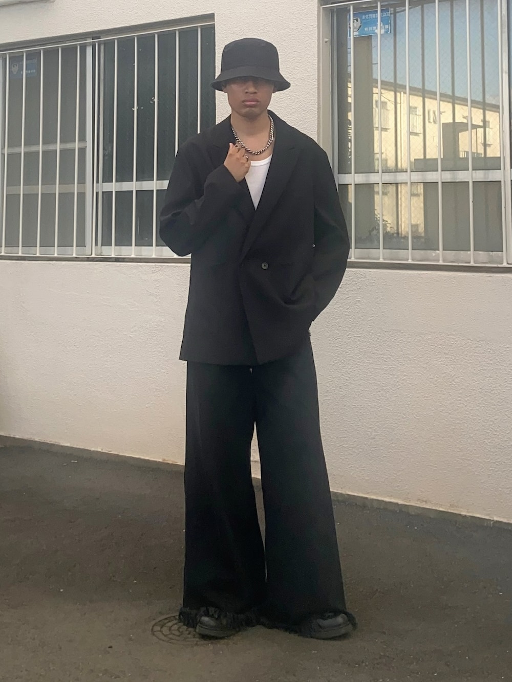 ブラック系のテーラードジャケット、ブラック系のデニムパンツを着用したメンズの秋コーディネートの2枚目の写真