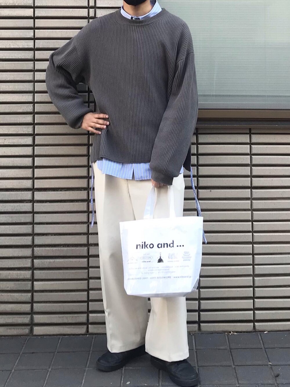グレー系のニット/セーター、ブルー系のシャツ/ブラウス、ホワイト系のスラックスを着用したメンズの春コーディネートの2枚目の写真