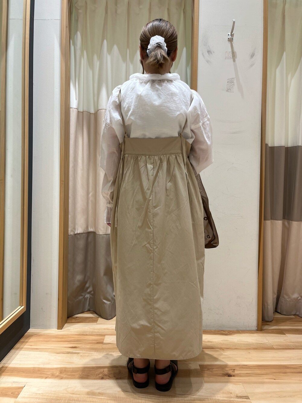 ブラウン系のハンドバッグ、ブラウン系のサンダル、ベージュ系のワンピースを着用したレディースの夏コーディネートの2枚目の写真