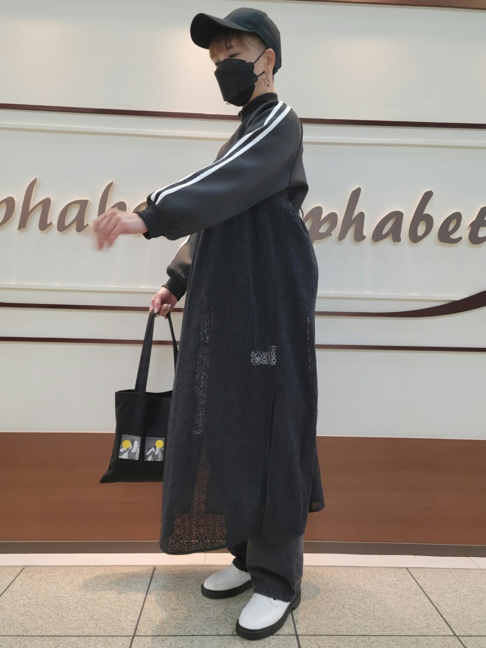 ブラック系のジャージ、ブラック系のワンピース、ブラック系のデニムパンツを着用したレディースの春コーディネートの2枚目の写真