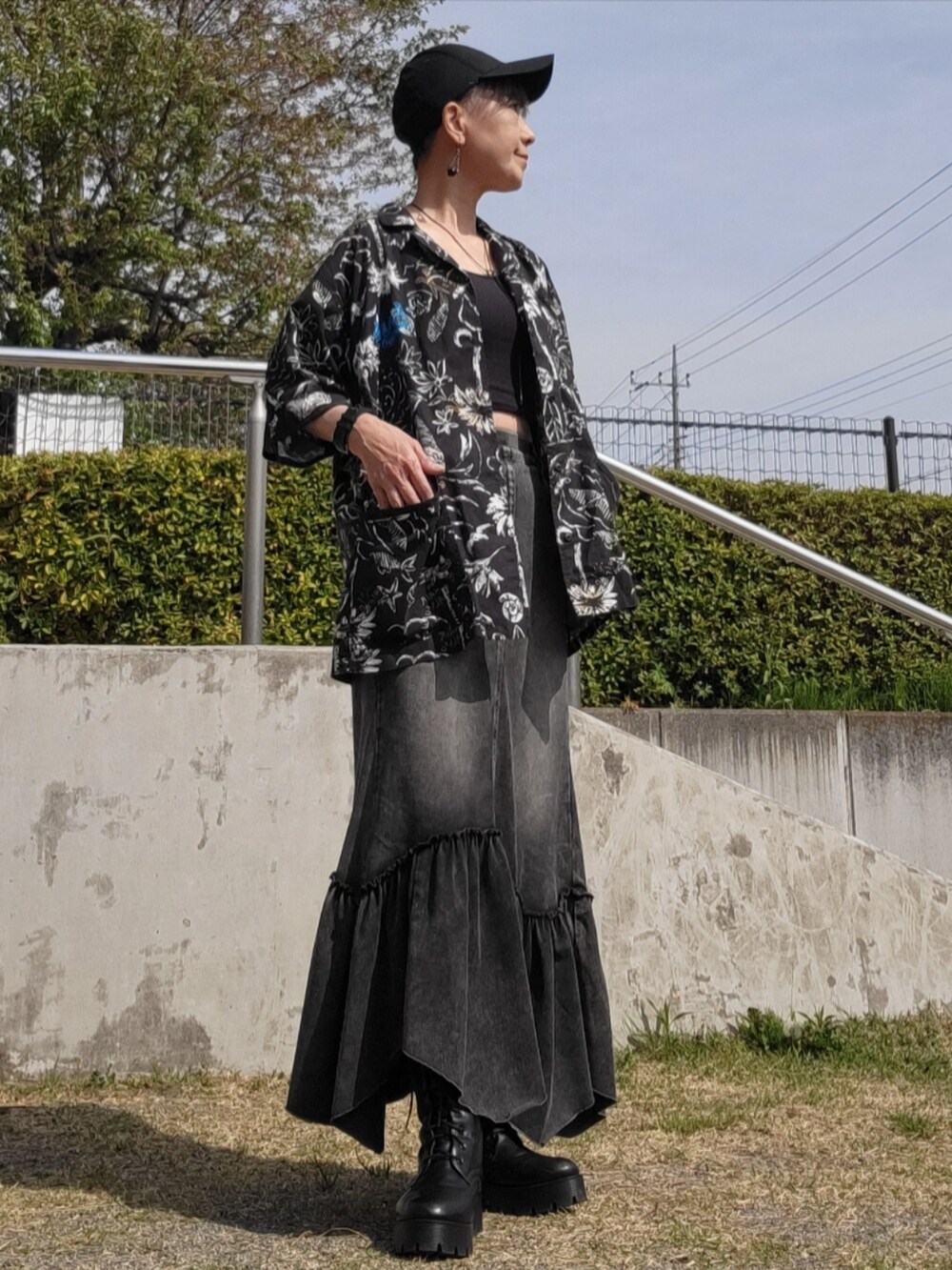 ブラック系のデニムスカート、ブラック系のシャツ/ブラウス、ブラック系のブーツを着用したレディースの春コーディネートの3枚目の写真