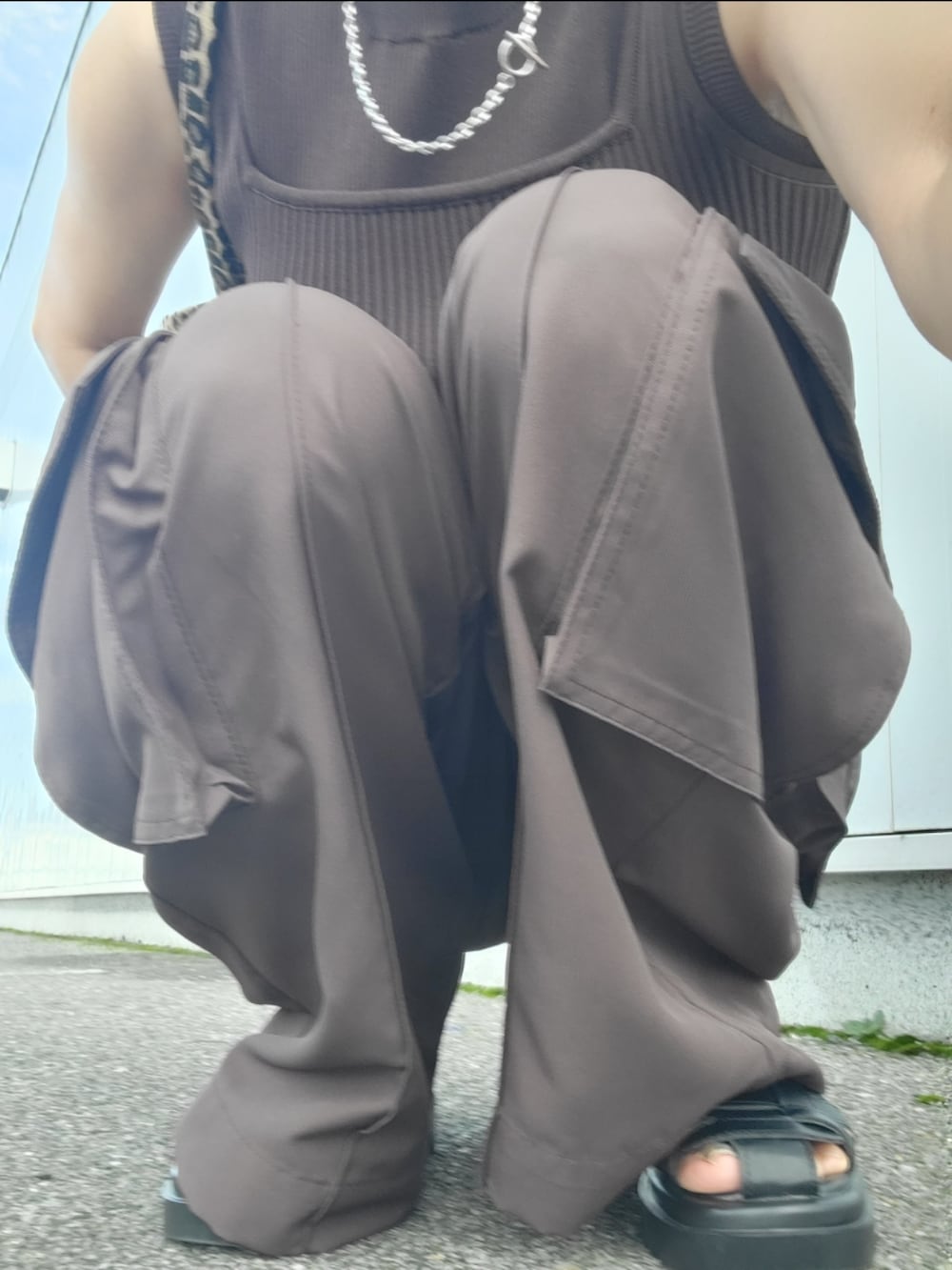 ブラウン系のスラックス、ブラウン系のタンクトップ、ブラック系のサンダルを着用したレディースの秋コーディネートの2枚目の写真