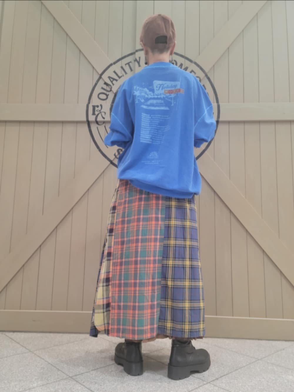 ブルー系のスウェット、グリーン系のシャツワンピース、ブラウン系のスカートを着用したレディースの春コーディネートの2枚目の写真