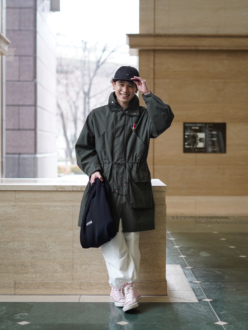 ブラック系のバッグ、ホワイト系のパンツ、ピンク系のスニーカーを着用したメンズの冬コーディネートの4枚目の写真