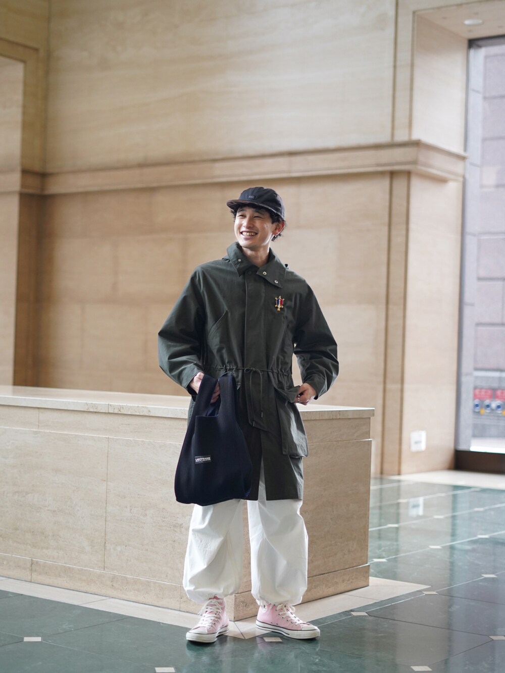 ブラック系のバッグ、ホワイト系のパンツ、ピンク系のスニーカーを着用したメンズの冬コーディネートの5枚目の写真