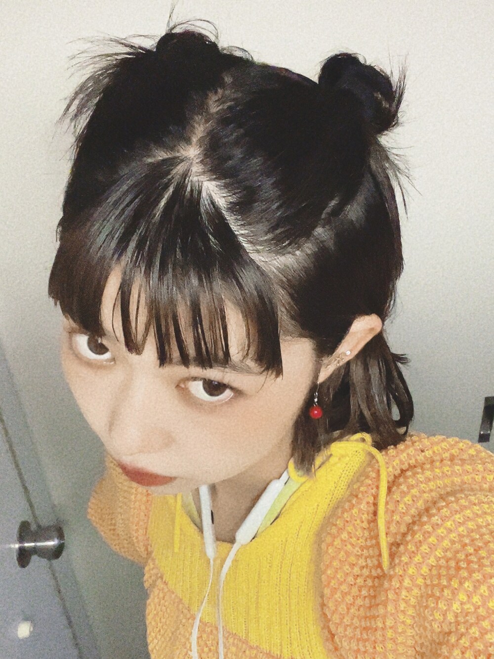 オレンジ系のニット/セーターを着用したレディースの冬コーディネートの2枚目の写真