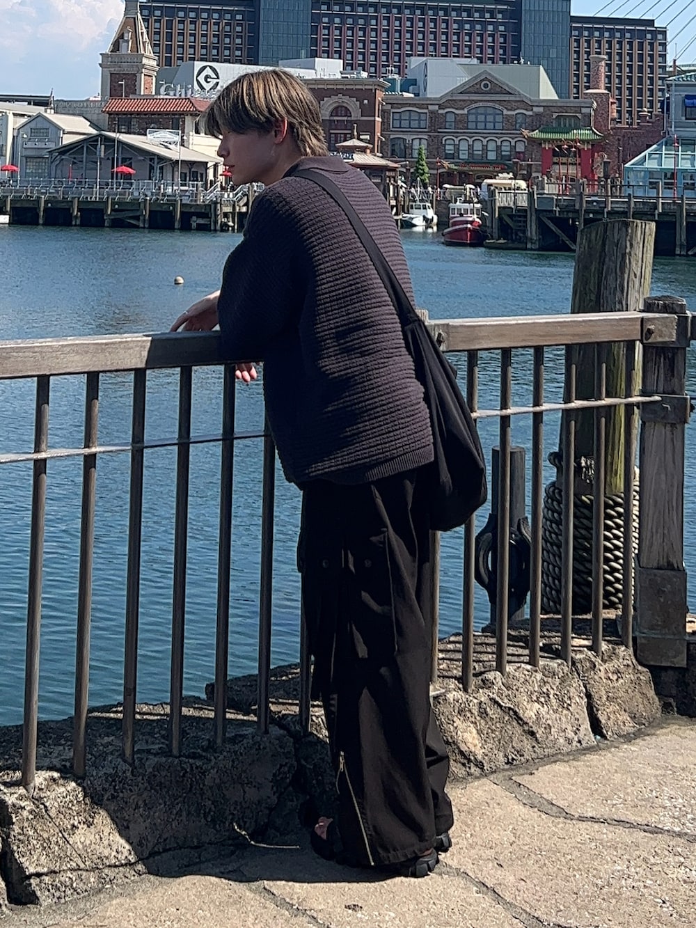 グレー系のポロシャツ、ブラック系のカーゴパンツ、ブラック系のサンダルを着用したメンズの夏コーディネートの2枚目の写真