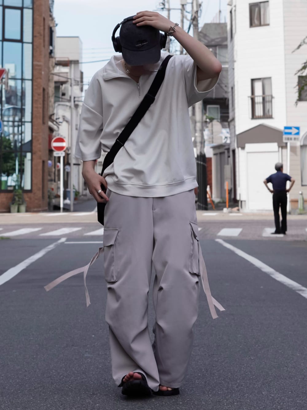 ホワイト系のTシャツ/カットソー、グレー系のカーゴパンツ、ブラック系のサンダルを着用したメンズの夏コーディネートの2枚目の写真