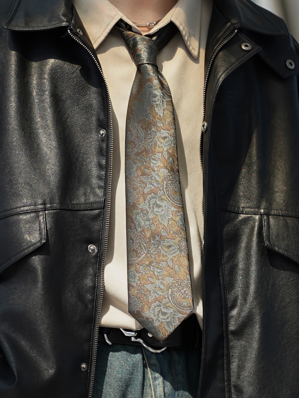 ブラック系のブルゾン、ベージュ系のシャツ/ブラウス、ブルー系のデニムパンツを着用したメンズの春コーディネートの4枚目の写真