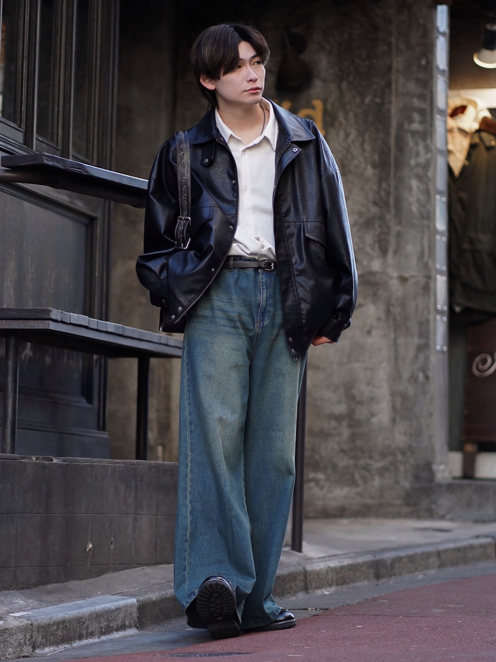 ブラック系のブルゾン、ホワイト系のシャツ/ブラウス、ブルー系のデニムパンツを着用したメンズの春コーディネートの2枚目の写真