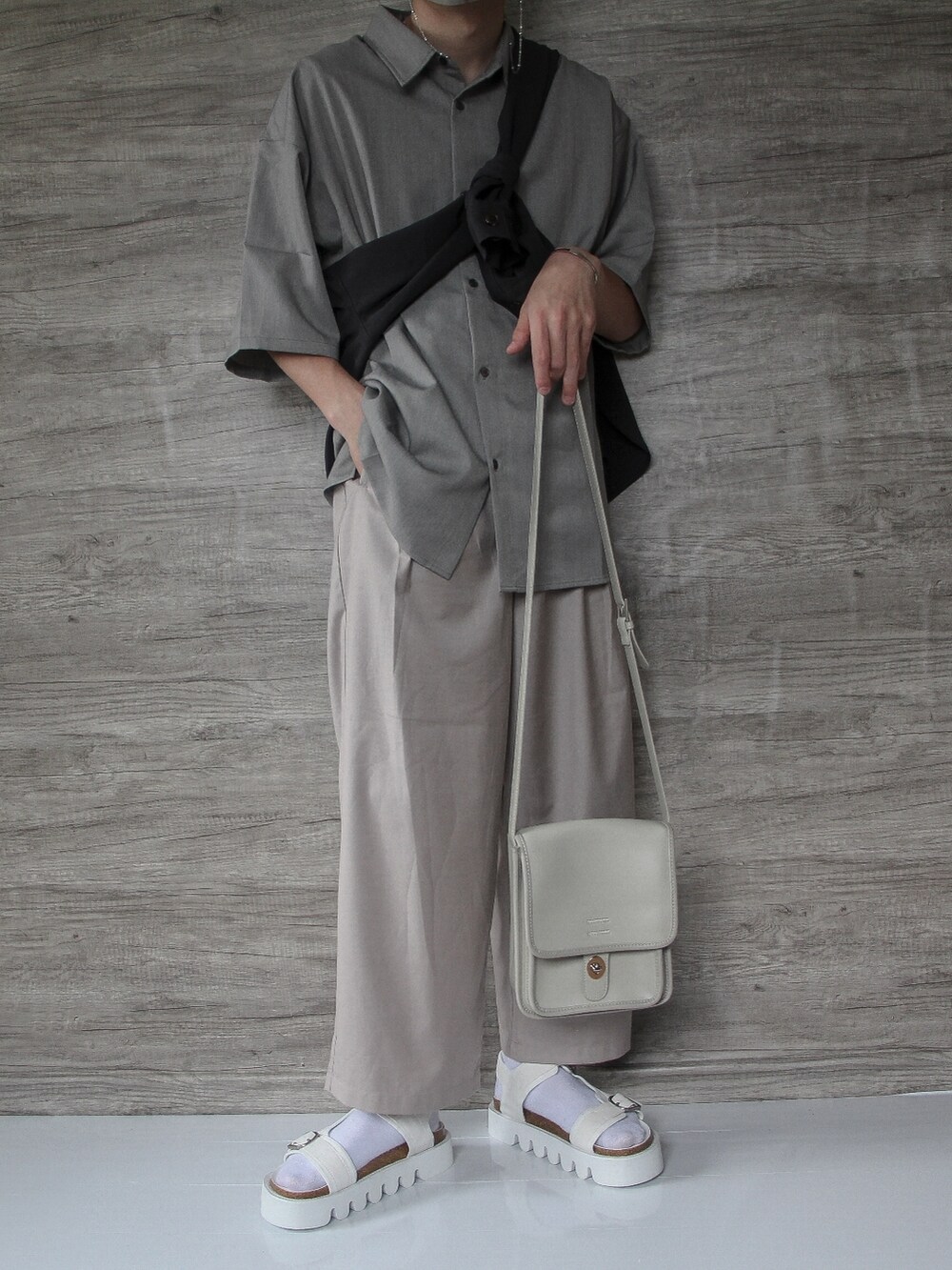 グレー系のシャツ/ブラウス、ベージュ系のスラックス、ホワイト系のサンダルを着用したメンズの春コーディネートの2枚目の写真