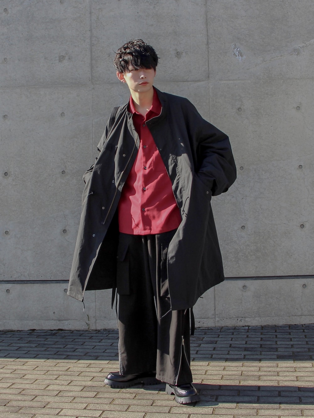 ブラック系のモッズコート、レッド系のシャツ/ブラウス、ブラック系のカーゴパンツを着用したメンズの冬コーディネートの2枚目の写真