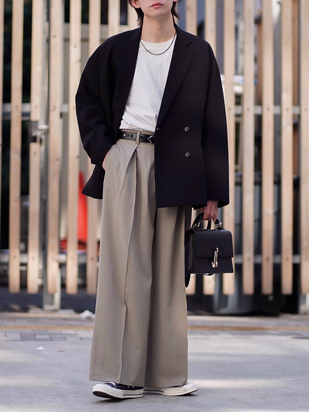 ブラック系のテーラードジャケット、ホワイト系のTシャツ/カットソー、ベージュ系のスラックスを着用したメンズの春コーディネートの3枚目の写真