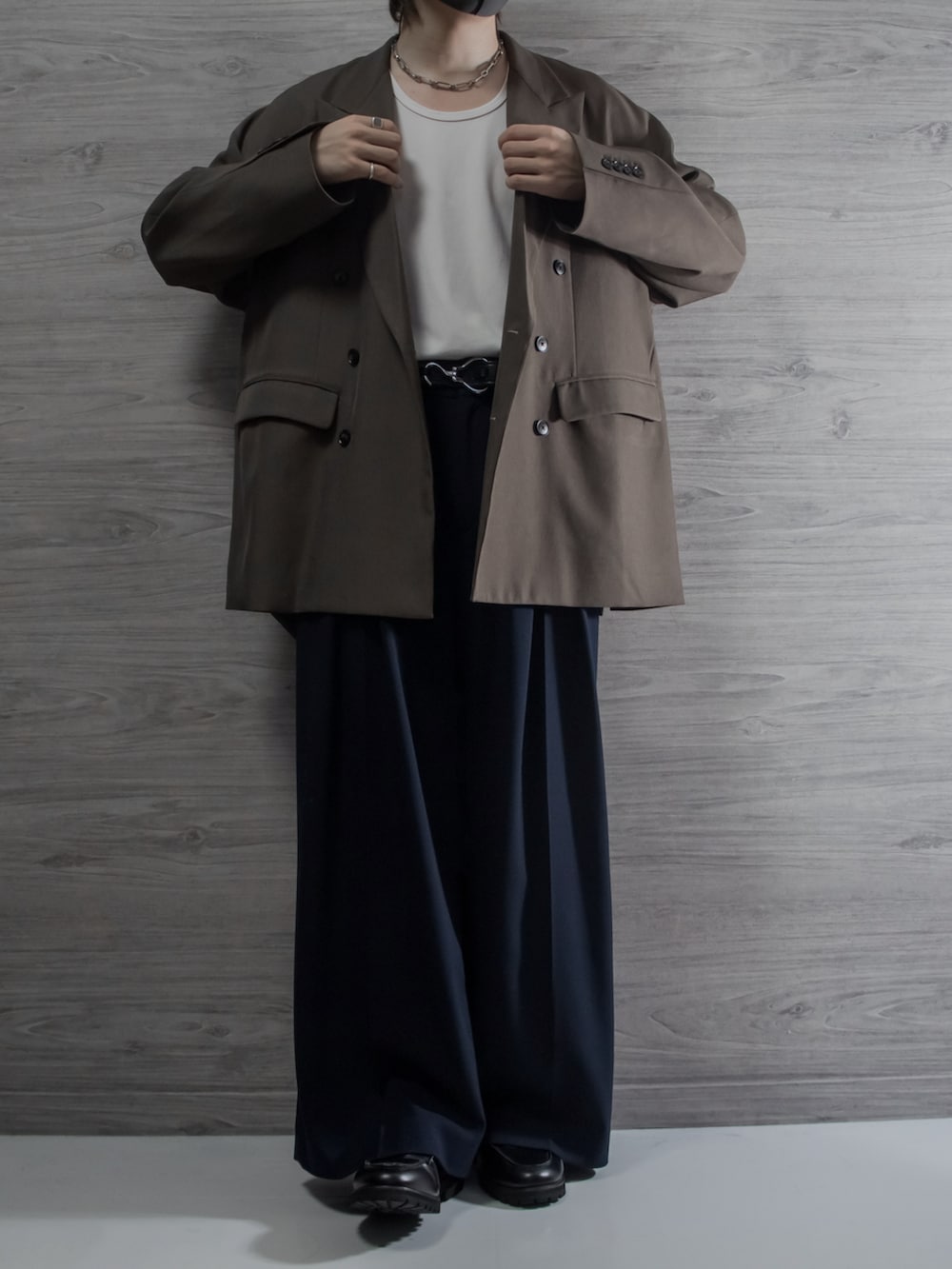 ブラウン系のテーラードジャケット、ブルー系のスラックス、ブラック系のローファーを着用したメンズの秋コーディネートの2枚目の写真