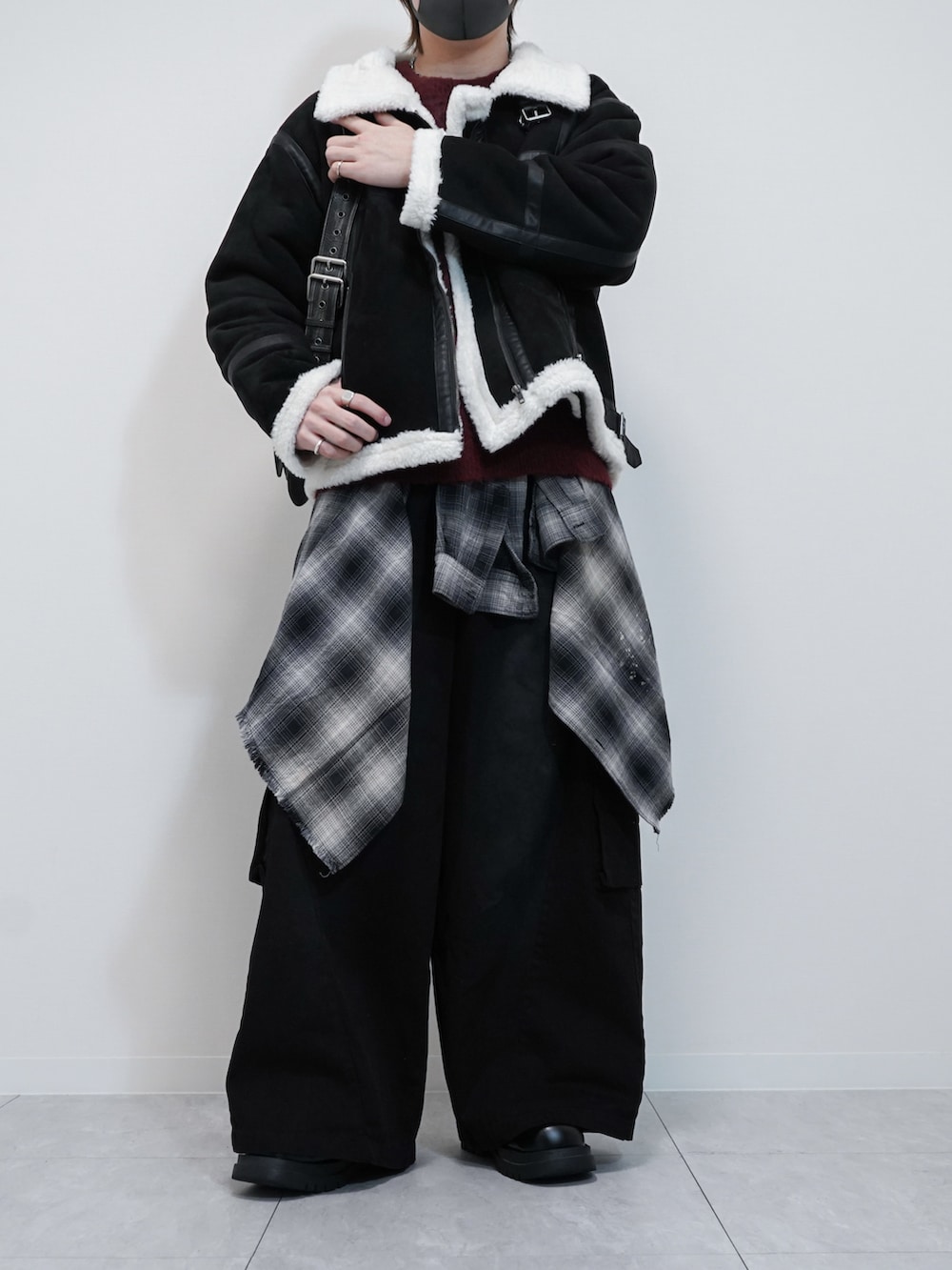 ホワイト系のムートンコート、レッド系のニット/セーター、ブラック系のカーゴパンツを着用したメンズの秋コーディネートの2枚目の写真