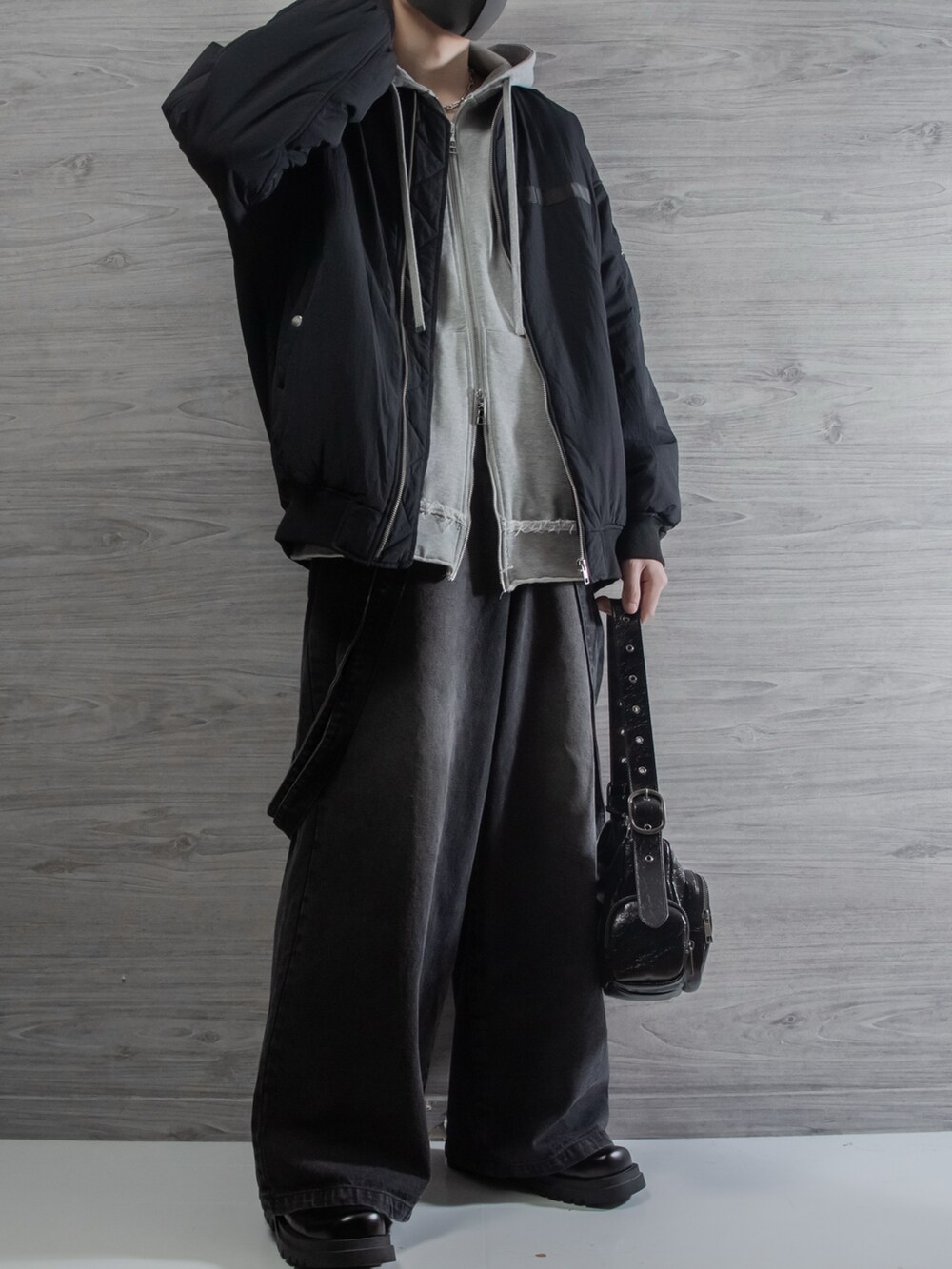 ブラック系のMA-1、グレー系のパーカー、グレー系のデニムパンツを着用したメンズの冬コーディネートの2枚目の写真