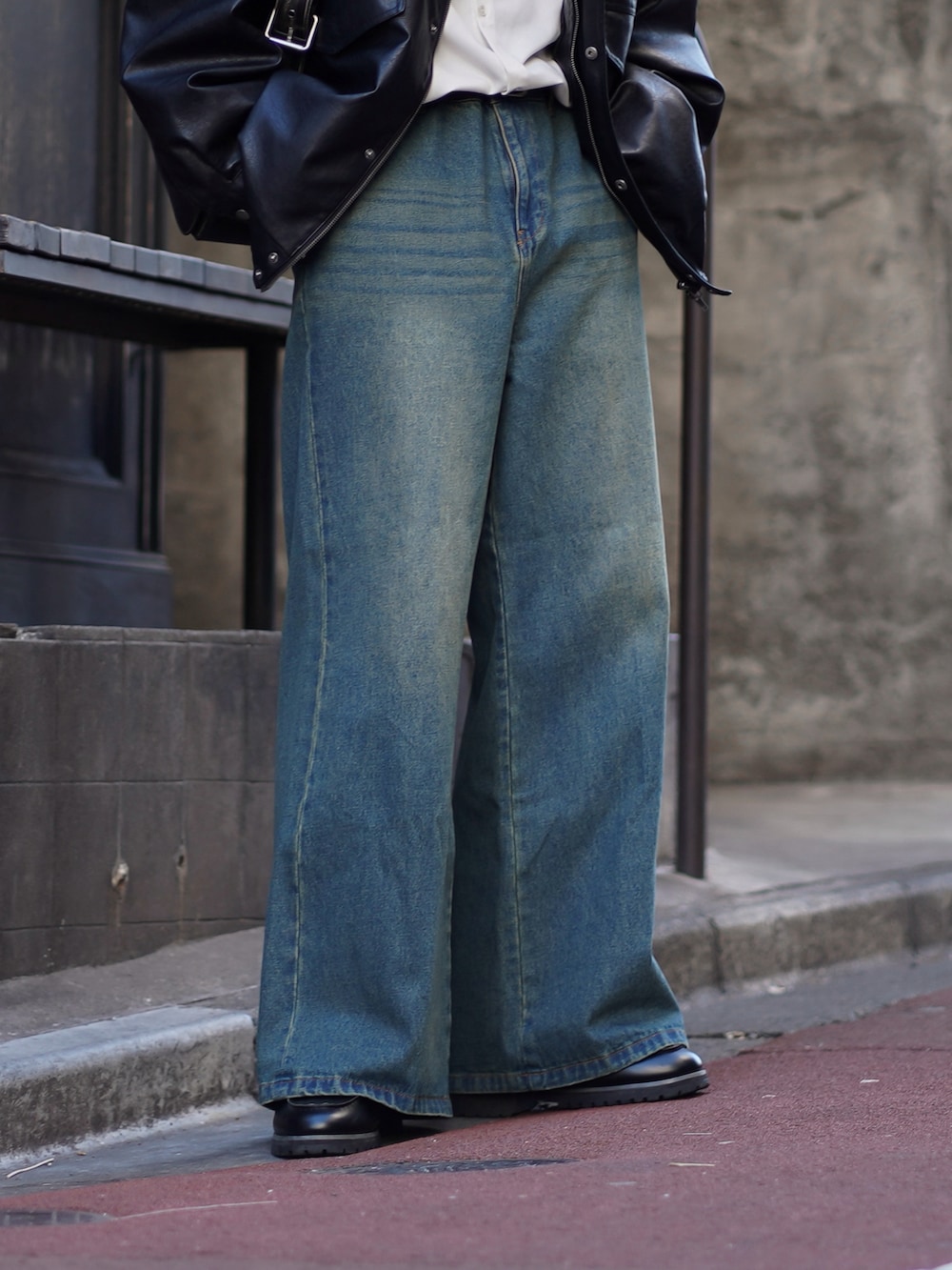 ブラック系のブルゾン、ホワイト系のシャツ/ブラウス、ブルー系のデニムパンツを着用したメンズの春コーディネートの4枚目の写真