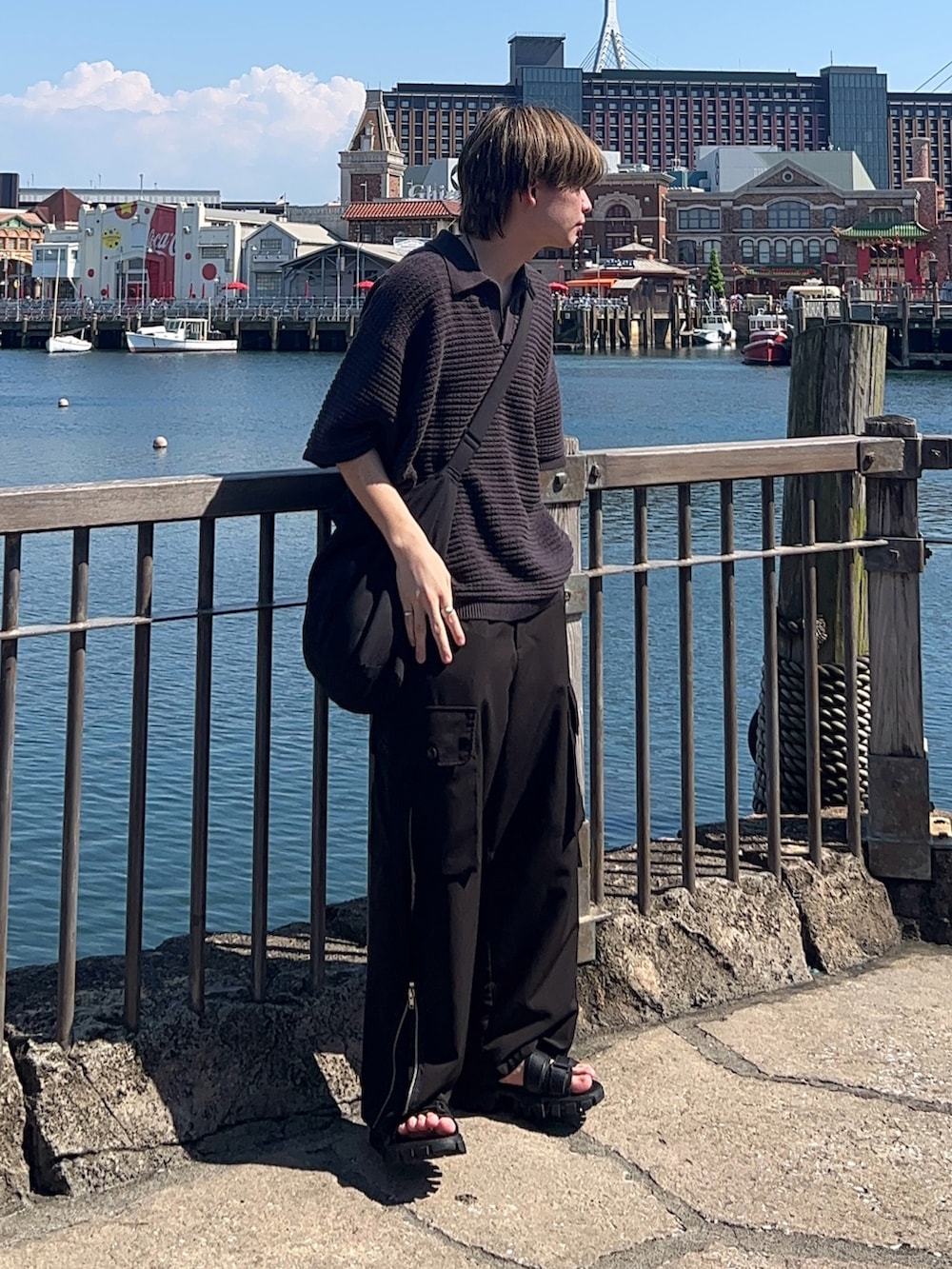 グレー系のポロシャツ、ブラック系のカーゴパンツ、ブラック系のサンダルを着用したメンズの夏コーディネートの3枚目の写真