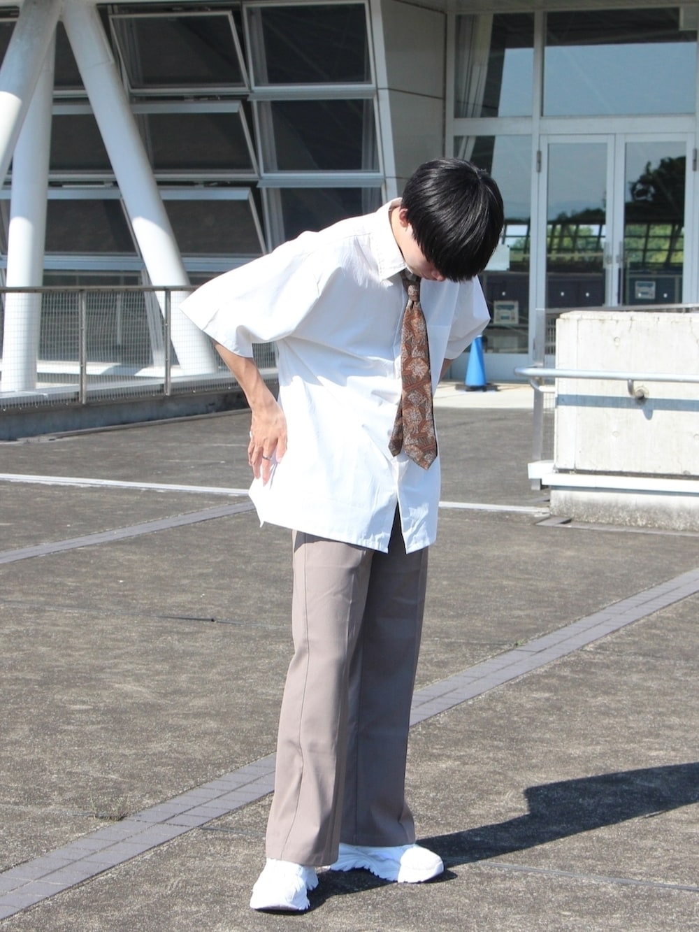 ベージュ系のその他パンツ、ホワイト系のシャツ/ブラウス、ブラウン系のネクタイを着用したメンズの春コーディネートの2枚目の写真