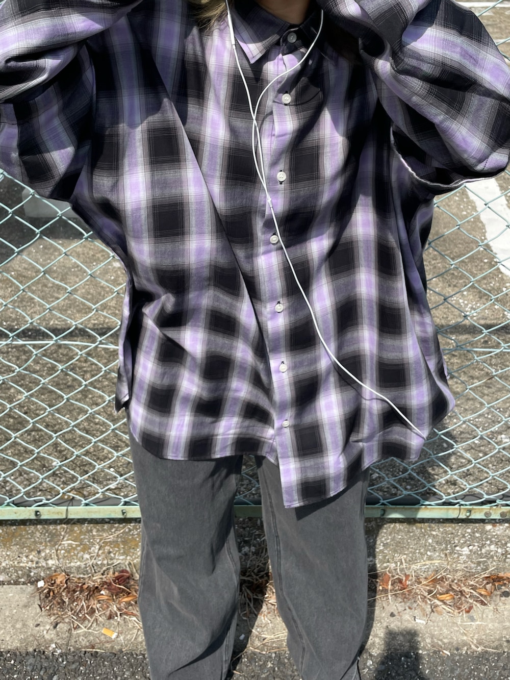 パープル系のシャツ/ブラウス、ブラック系のデニムパンツ、ブルー系のスニーカーを着用したレディースの秋コーディネートの2枚目の写真