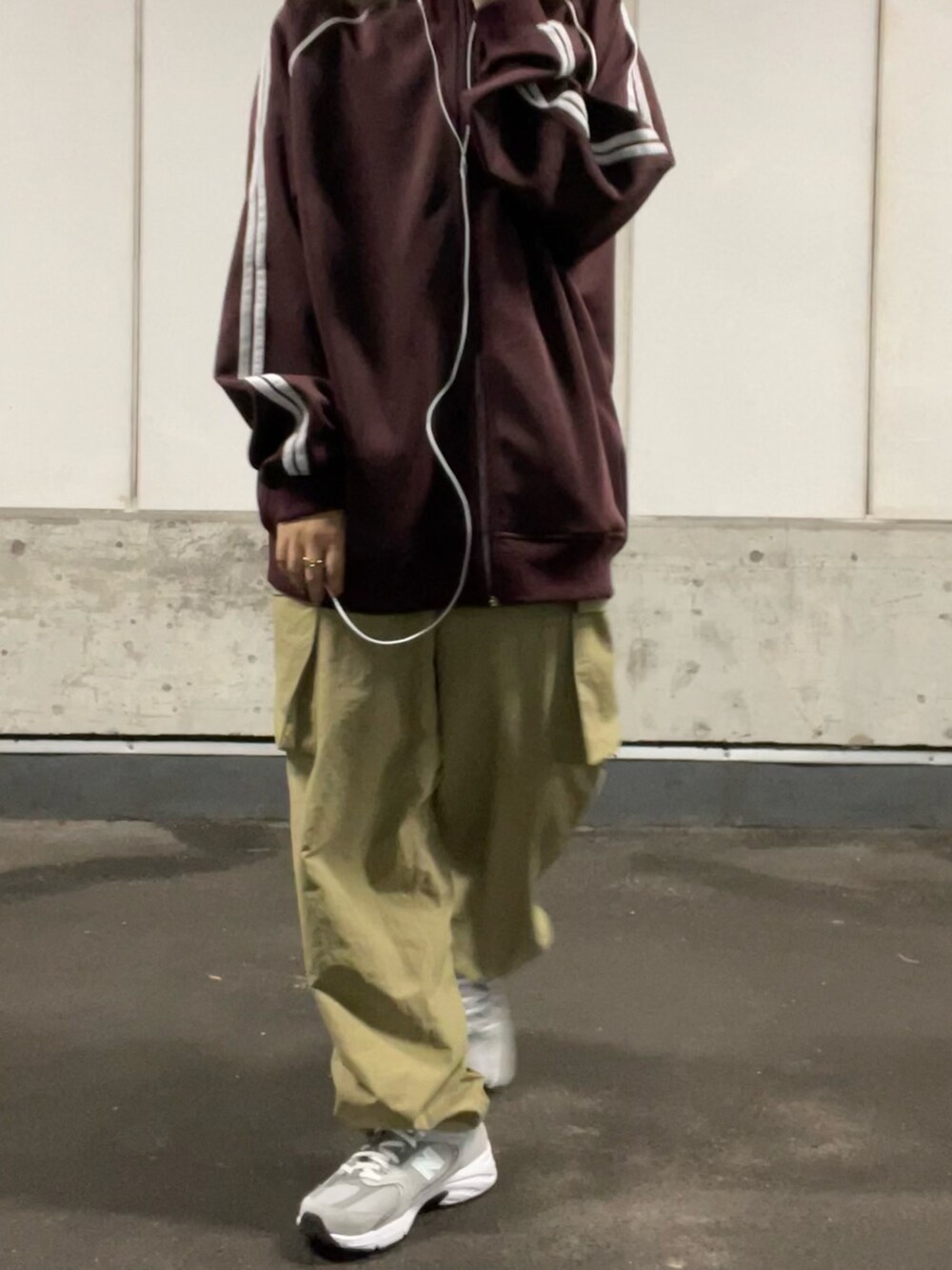 レッド系のジャケット/アウター、グリーン系のカーゴパンツ、グレー系のスニーカーを着用したレディースの秋コーディネートの3枚目の写真