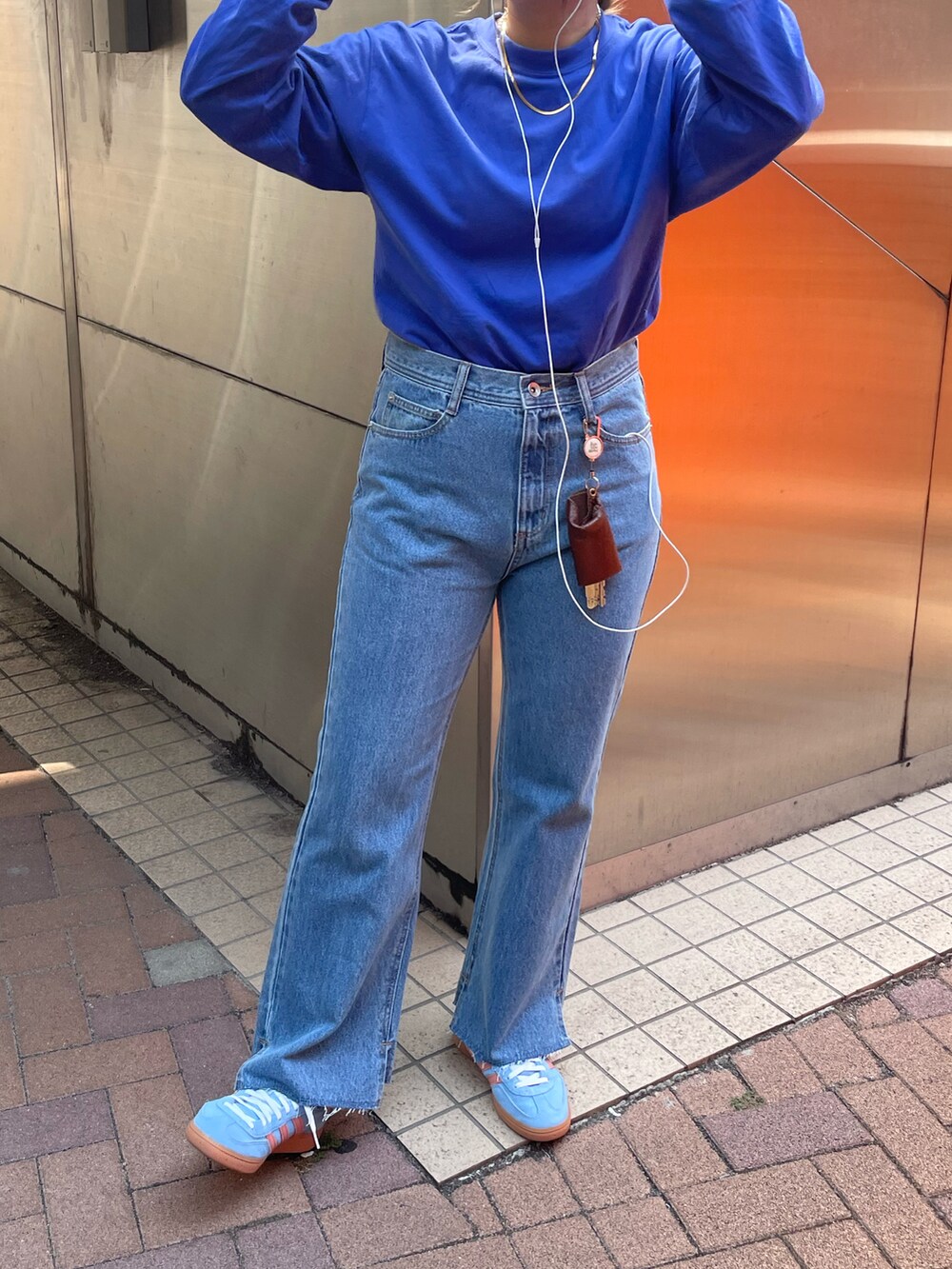 ブルー系のTシャツ/カットソー、ブルー系のデニムパンツ、ブルー系のスニーカーを着用したレディースの秋コーディネートの2枚目の写真