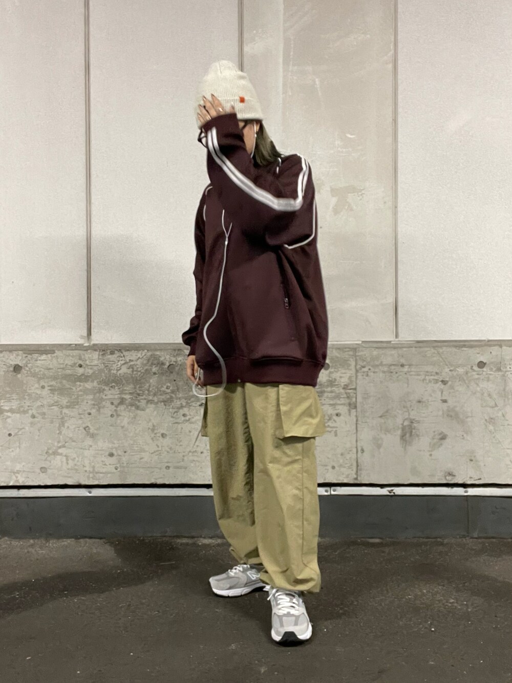 レッド系のジャケット/アウター、グリーン系のカーゴパンツ、グレー系のスニーカーを着用したレディースの秋コーディネートの2枚目の写真