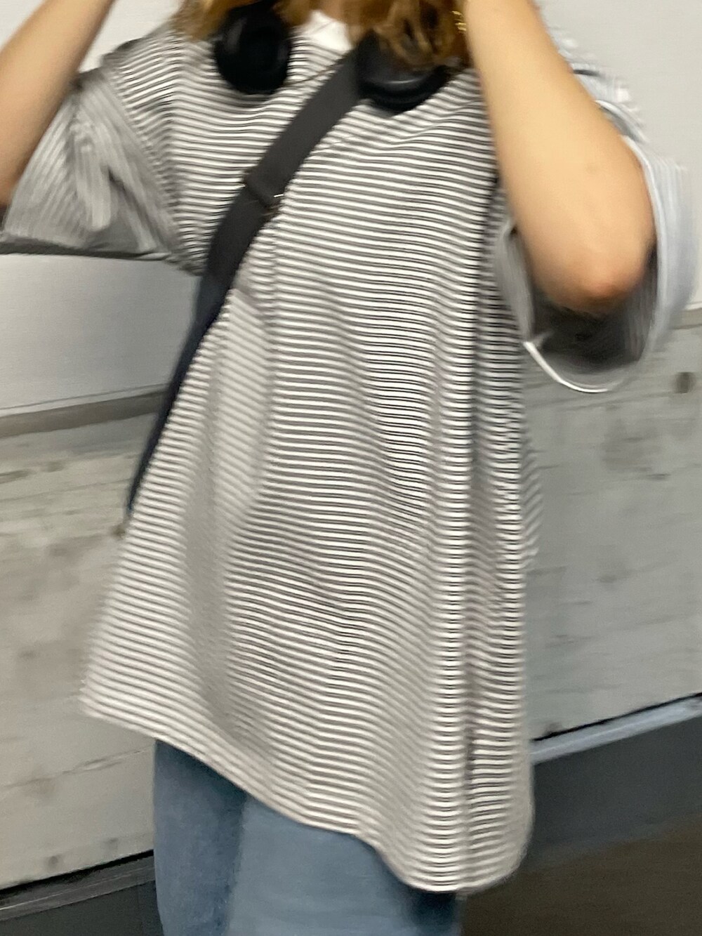 ブルー系のデニムパンツ、ブラウン系のスニーカー、ホワイト系のTシャツ/カットソーを着用したレディースの夏コーディネートの3枚目の写真